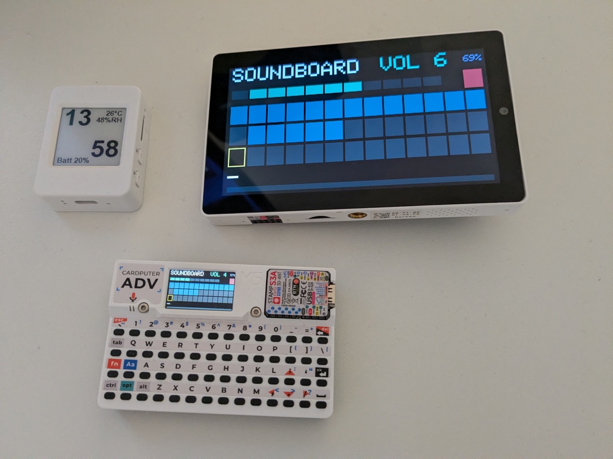 Three boards on the bench: the e-paper device, a 5" RISC-V tablet and a keyboard handheld, the last two running the same grid interface